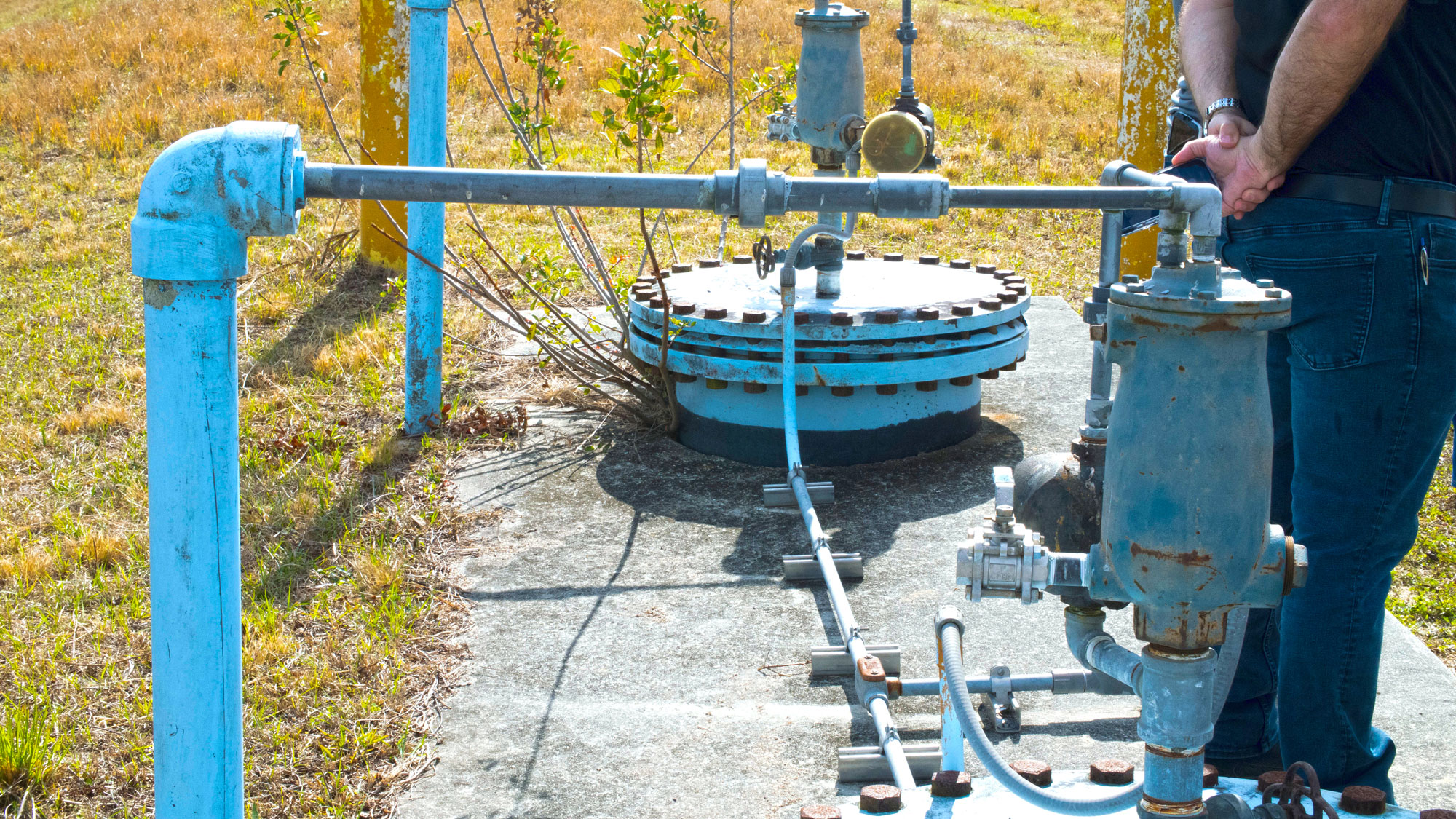 Monitoring well and pipes on the land around Taylor Creek Reservoir.